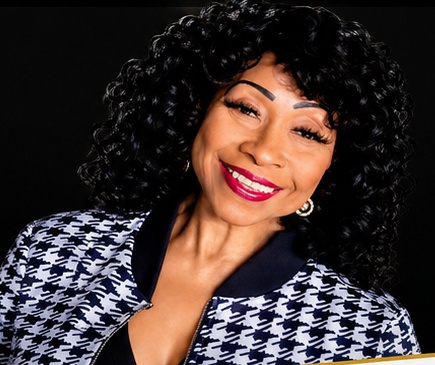 Sharon Ogbueze smiling in a black and white jacket